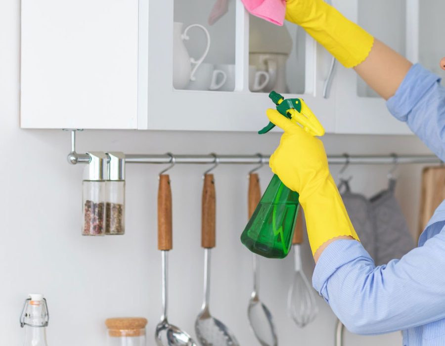 young-woman-cleaning-shelfs-at-home-at-kitchen